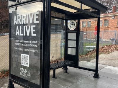 Image of black bus shelter with Vision Zero advertisement